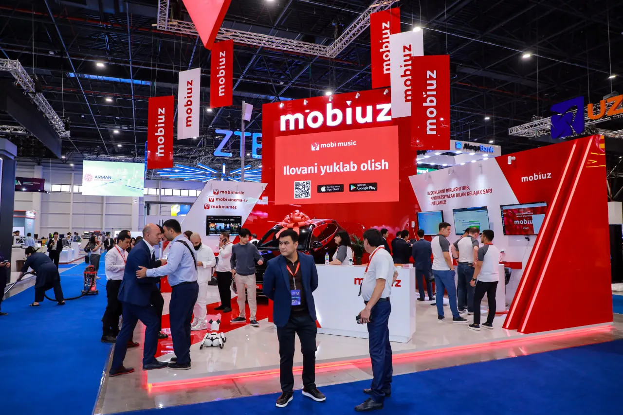 Красный выставочный стенд Mobiuz с высокими пилонами, крупной вывеской и светящимся контуром подиума в CAEx.
