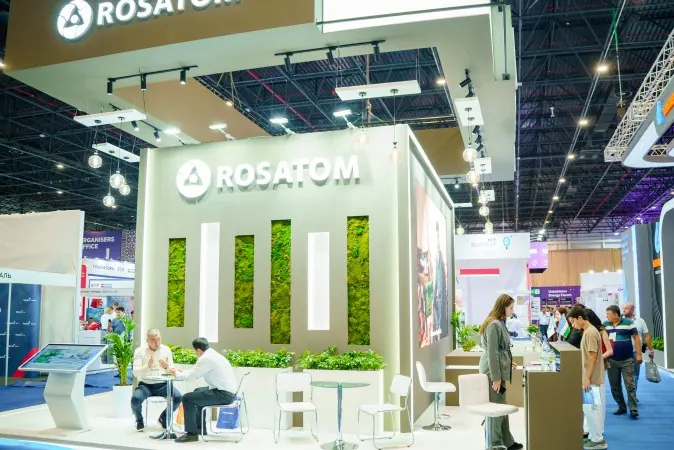 Стенд ROSATOM с белыми объёмными световыми буквами, подвесной конструкцией и зелёными декоративными вставками в CAEx.