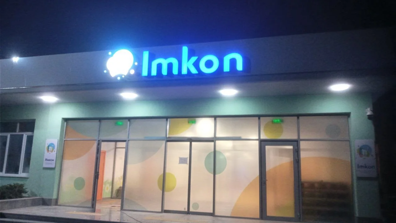 Светящийся логотип Imkon над входом в здание
